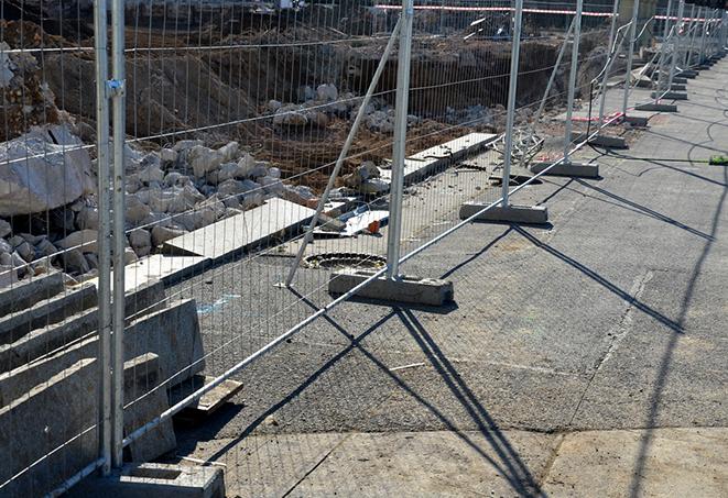 a row of sturdy temporary fence panels separating a job site from surrounding areas